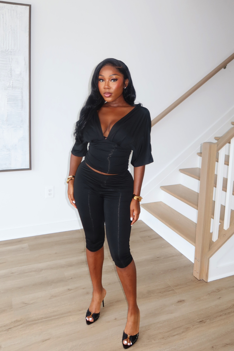 Woman wearing Demuluxe Vale Capri Set, a plunge-neckline two-piece with cinched waist and fitted capri pants