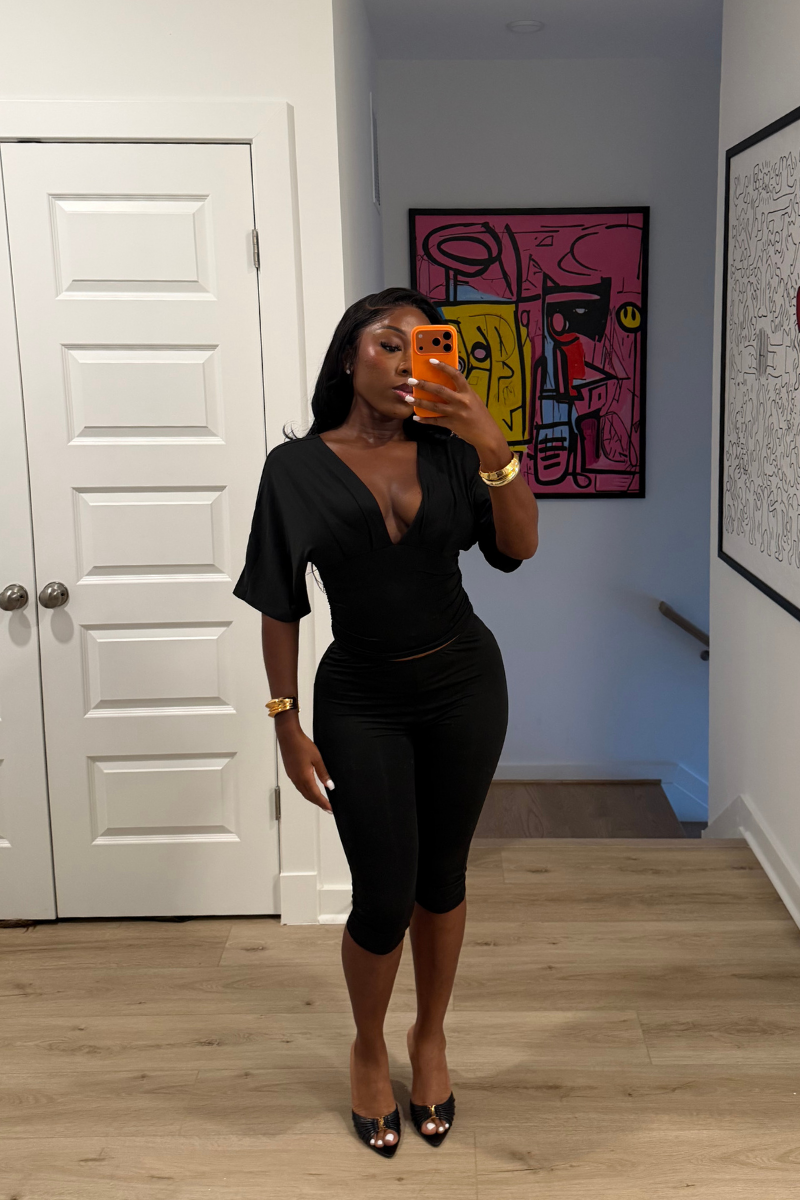 Woman wearing Demuluxe Vale Capri Set, a plunge-neckline two-piece with cinched waist and fitted capri pants