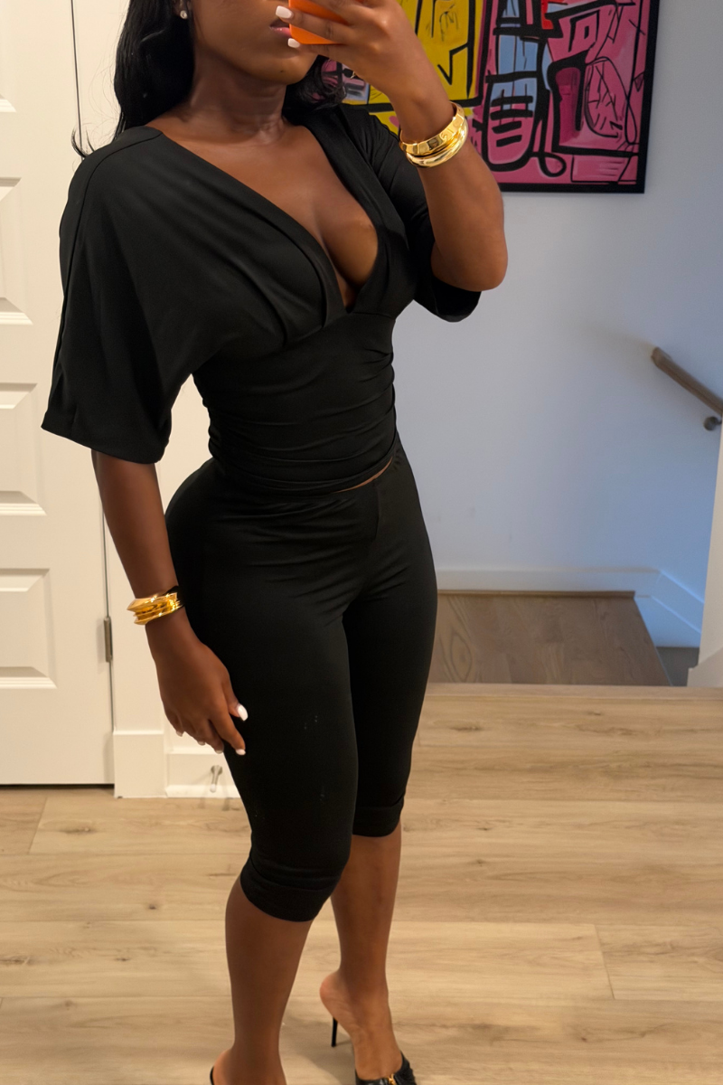Woman wearing Demuluxe Vale Capri Set, a plunge-neckline two-piece with cinched waist and fitted capri pants