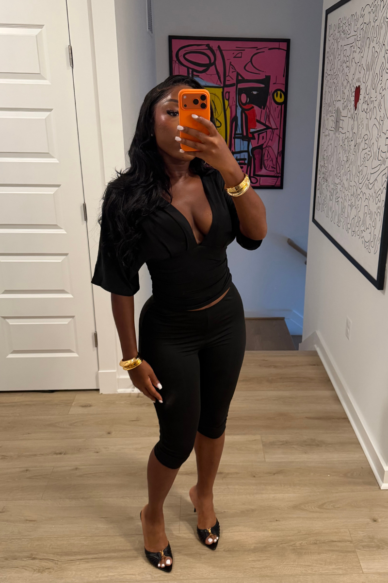 Woman wearing Demuluxe Vale Capri Set, a plunge-neckline two-piece with cinched waist and fitted capri pants