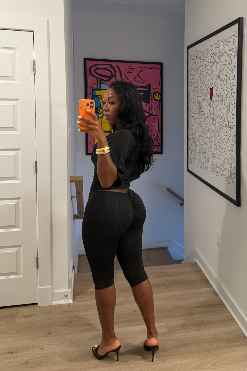 Woman wearing Demuluxe Vale Capri Set, a plunge-neckline two-piece with cinched waist and fitted capri pants