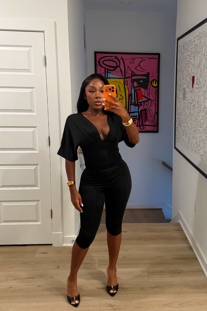 Woman wearing Demuluxe Vale Capri Set, a plunge-neckline two-piece with cinched waist and fitted capri pants