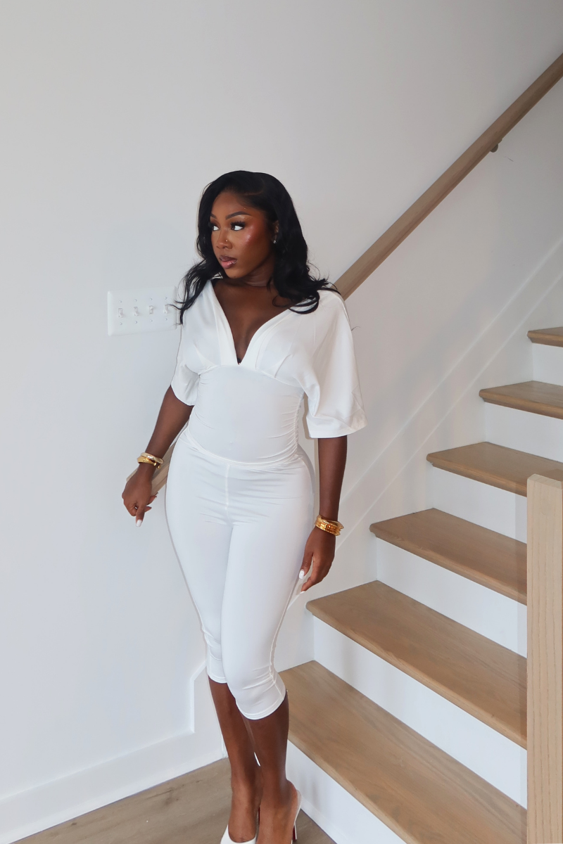 Woman wearing Demuluxe Vale Capri Set, a plunge-neckline two-piece with cinched waist and fitted capri pants