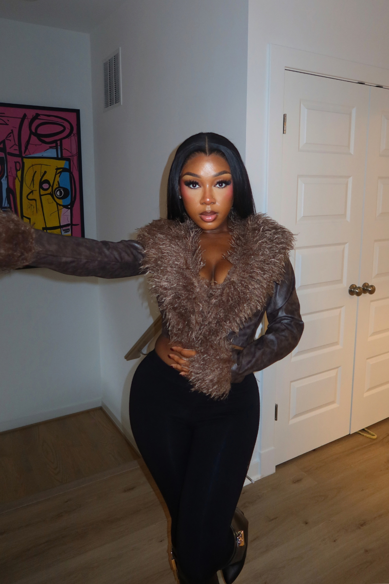 Woman wearing Demuluxe Opal Jacket, a cropped faux fur and leather jacket in brown