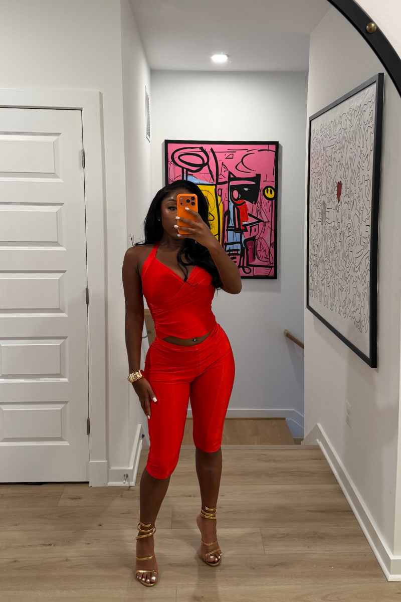 Woman wearing Demuluxe Reya Halter Capri Set, a red crossover halter top with matching high-waisted capri pants