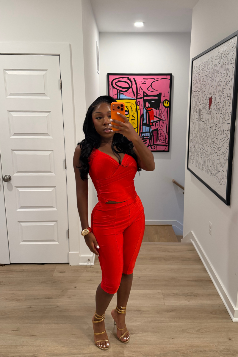 Woman wearing Demuluxe Reya Halter Capri Set, a red crossover halter top with matching high-waisted capri pants