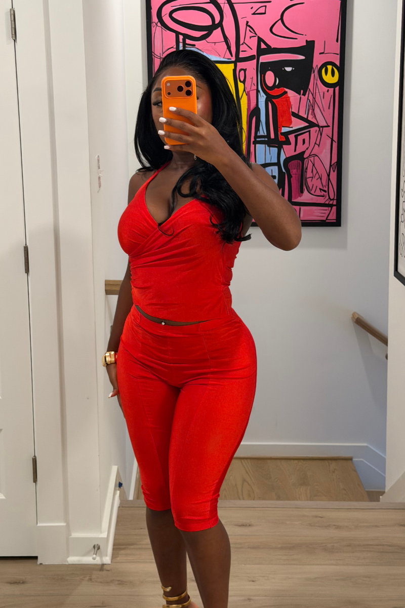 Woman wearing Demuluxe Reya Halter Capri Set, a red crossover halter top with matching high-waisted capri pants