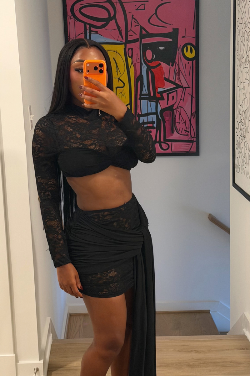 Woman wearing Demuluxe Odessa Lace Set, a black sheer lace crop top and mini skirt with draped tails