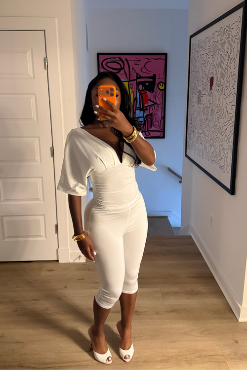 Woman wearing Demuluxe Vale Capri Set, a plunge-neckline two-piece with cinched waist and fitted capri pants