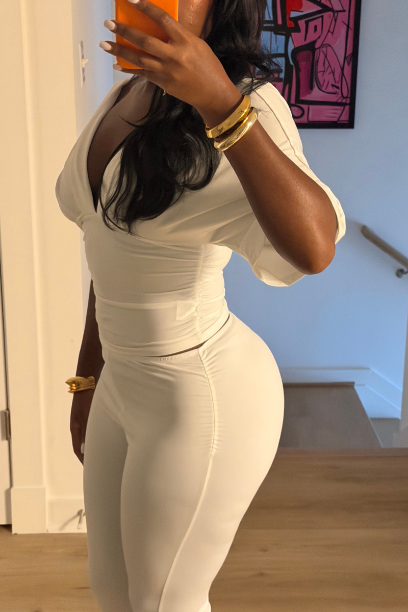 Woman wearing Demuluxe Vale Capri Set, a plunge-neckline two-piece with cinched waist and fitted capri pants