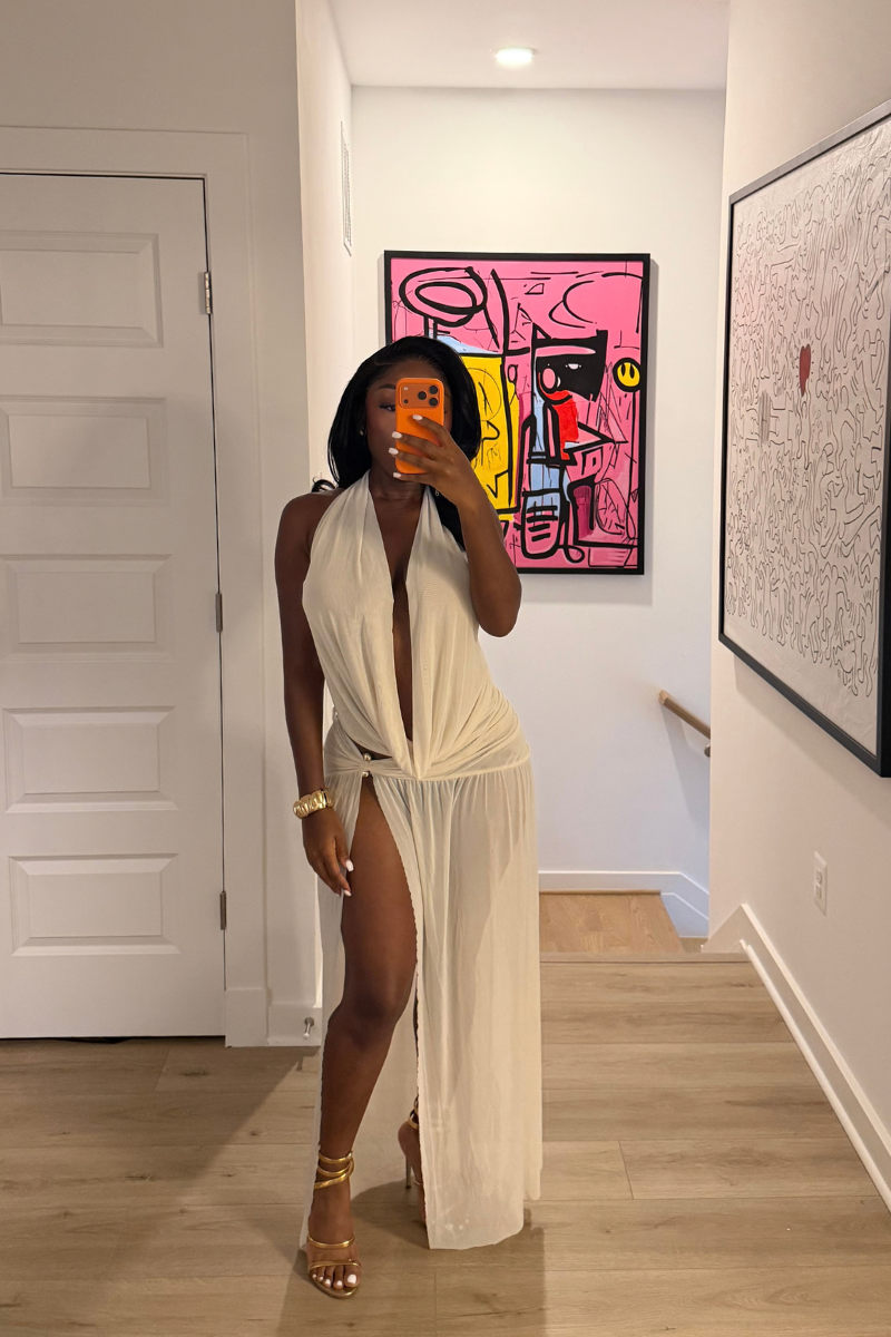 Woman wearing Demuluxe Farrah Skirt Set, a cream draped halter top and matching maxi skirt with front slit