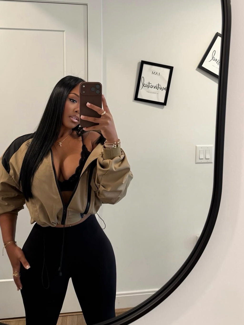 Woman wearing Demuluxe Remy Bomber Jacket, a cropped tan utility bomber with black paneling and drawstring hem 